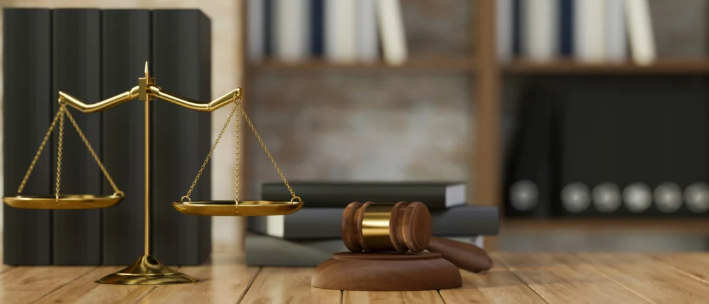 Justitiawaage und Richterhammer, die auf einem Tisch stehen